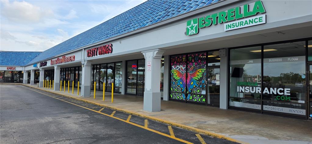 A row of commercial storefronts with a blue tiled roof in a strip mall — 856 N NOVA, DAYTONA BEACH, FL