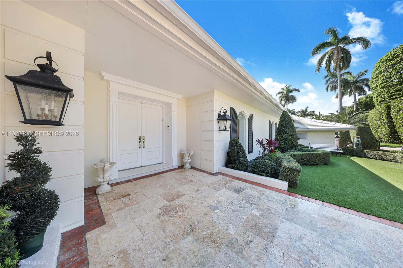 A stone-paved entryway leads to white double doors on a house with palm trees — 55 La Gorce Cir, Miami Beach FL 33141, MIAMI BEACH, FL