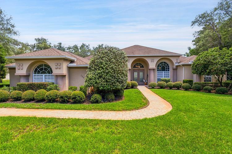 A tan, single-story suburban house with a paved walkway and manicured lawn — 10470 RAMBLE RIDGE COURT, WEEKI WACHEE, FL