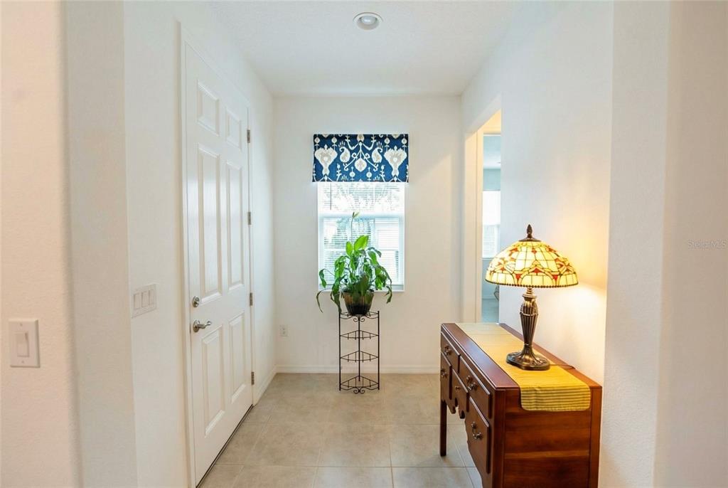 An entryway features tile flooring, a white door, a window with a valance, and furniture — 9222 SW 97TH CIRCLE, OCALA, FL
