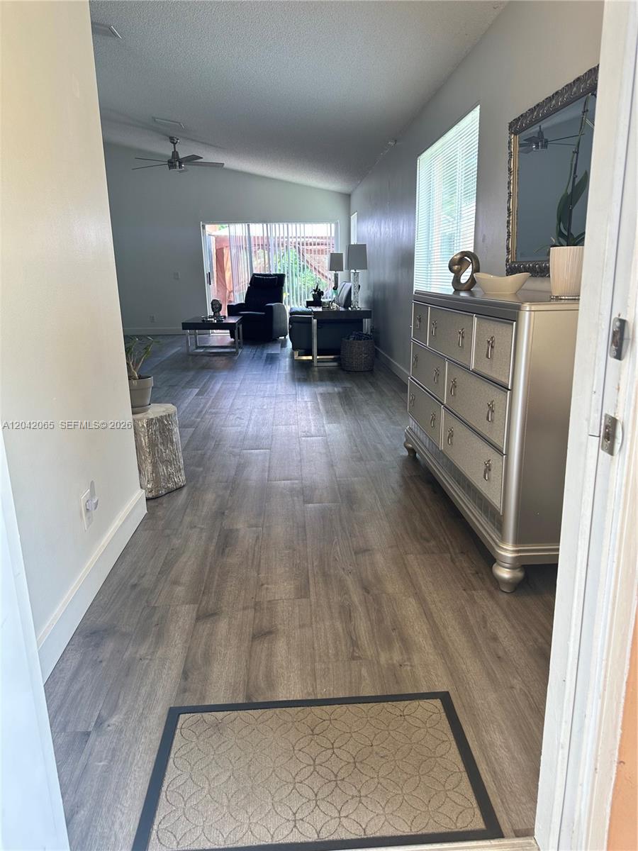 A view from a doorway into a living area with gray wood-look flooring and furniture — 4025 Pine Ridge Ln, Weston FL 33331, WESTON, FL