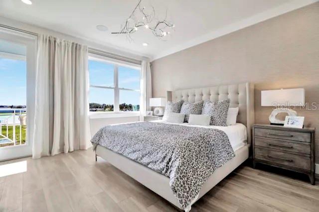 A bedroom features a tufted headboard, a leopard-print bedspread, and a view of the water — 31850 CLOVER FIN COURT, WESLEY CHAPEL, FL