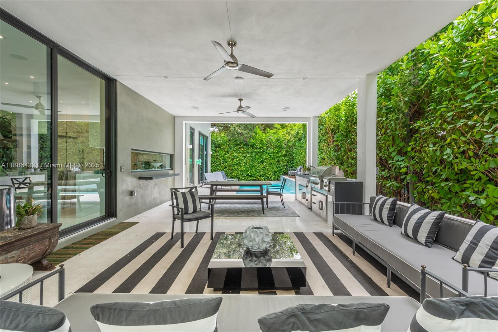 A covered outdoor patio features a dining area, kitchen, lounge seating, and a swimming pool — 4675 NE 2nd Ave, Miami FL 33137, MIAMI, FL