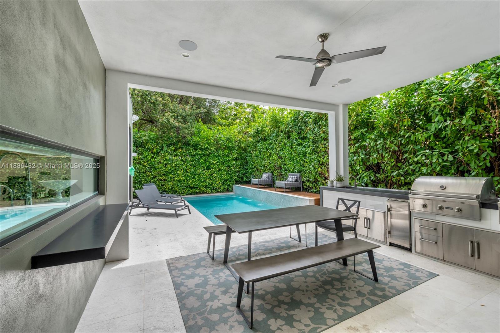 A covered patio features an outdoor kitchen, dining area, and a swimming pool — 4675 NE 2nd Ave, Miami FL 33137, MIAMI, FL
