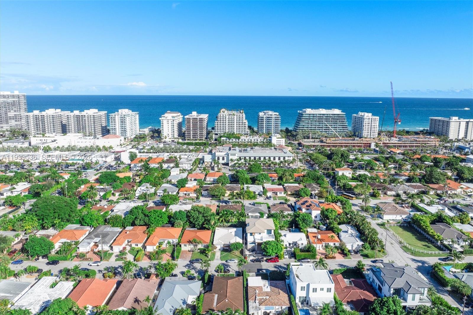 An aerial view shows a residential neighborhood with houses leading toward a coastal skyline — 9424 - 9432 Carlyle Ave, Surfside FL 33154, SURFSIDE, FL