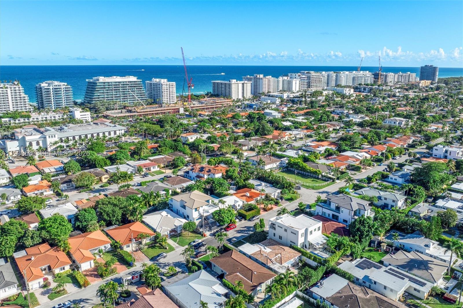 An aerial view shows a residential neighborhood with houses and trees near a coastal city — 9424 - 9432 Carlyle Ave, Surfside FL 33154, SURFSIDE, FL