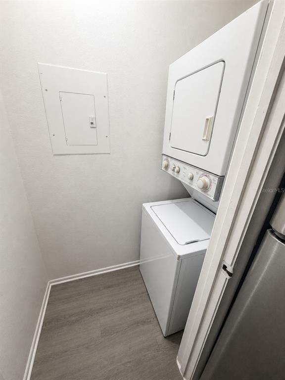 A laundry closet contains a stacked white washer and dryer unit next to a wall panel — 249 AFTON SQUARE UNIT 107, ALTAMONTE SPRINGS, FL