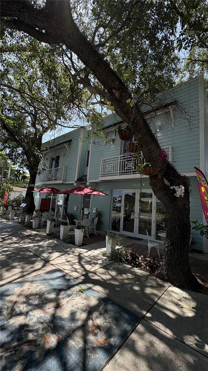 A two-story light blue building with a salon entrance and outdoor patio seating — 3872 Grand Ave # A, Miami FL 33133, MIAMI, FL