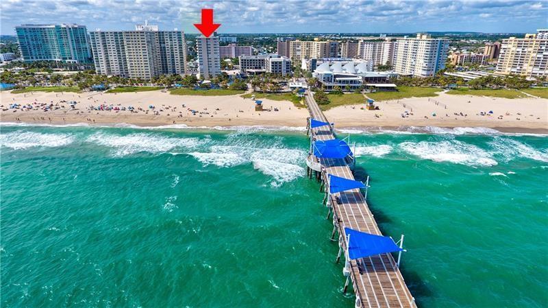 An aerial view shows a beach with a long pier and several high-rise buildings — 133 N Pompano Beach Boulevard # 806, Pompano Beach FL 33062, POMPANO BEACH, FL
