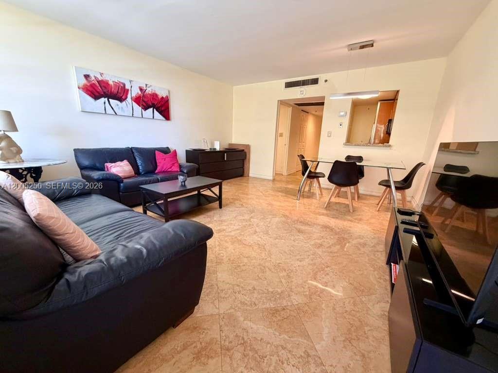 A living and dining area features tile flooring, black leather sofas, and a glass dining table — 100 Lincoln Rd # 534, Miami Beach FL 33139, MIAMI BEACH, FL