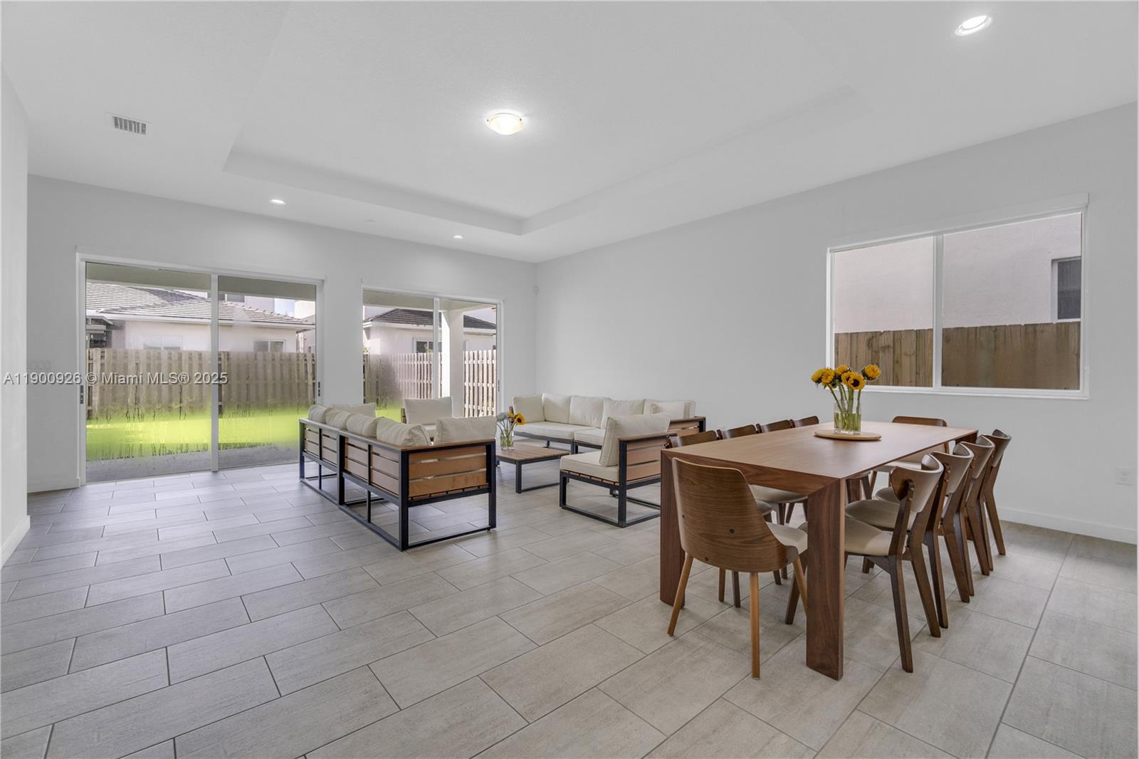 A spacious open-concept living and dining area features tile flooring and sliding glass doors — 15288 SW 176th Ter, Miami FL 33187, MIAMI, FL