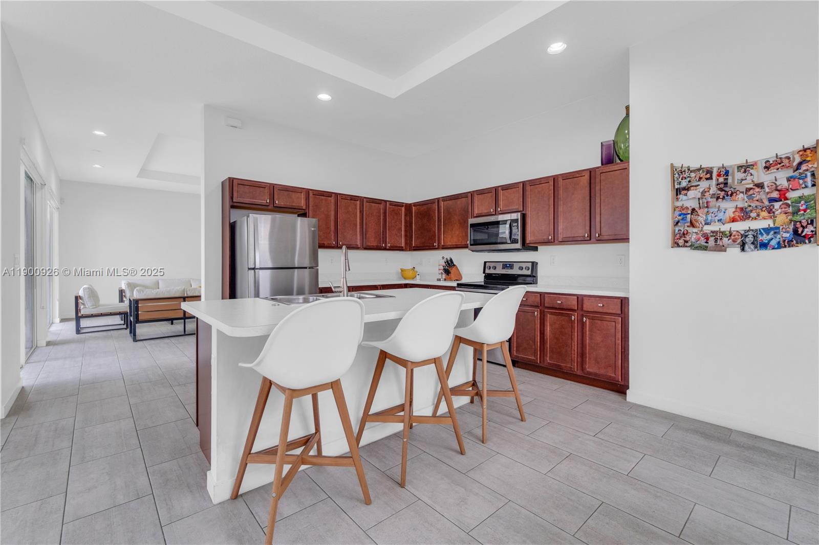A kitchen features dark wood cabinets, stainless steel appliances, and a white island with stools — 15288 SW 176th Ter, Miami FL 33187, MIAMI, FL
