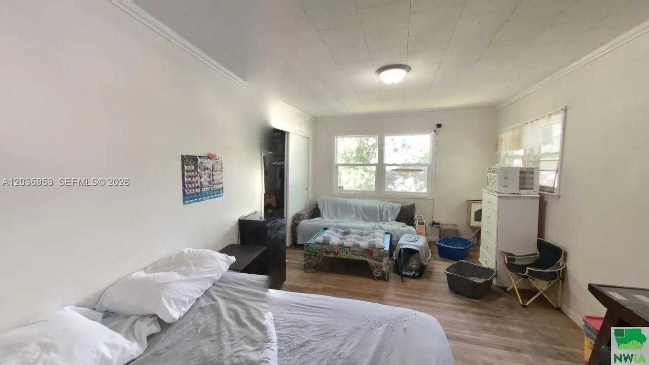 A bedroom features light wood-look flooring, white walls, a bed, and a window with blinds — 35 Hinshaw St, IA 51331, IA