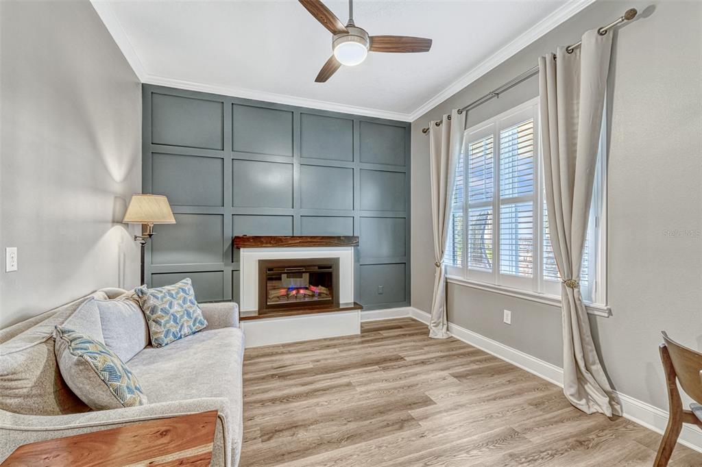 A living room features a gray paneled accent wall, a fireplace, and light wood flooring — 13347 GABOR AVENUE, ORLANDO, FL
