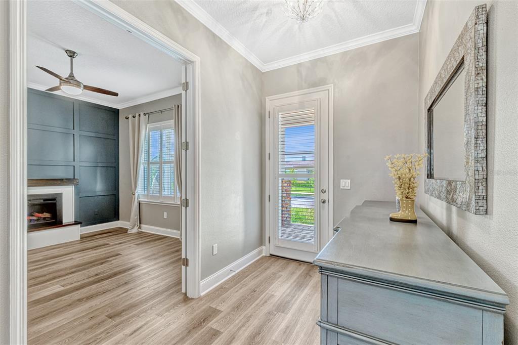 An entryway with light wood floors, a gray dresser, and a doorway to a living room — 13347 GABOR AVENUE, ORLANDO, FL