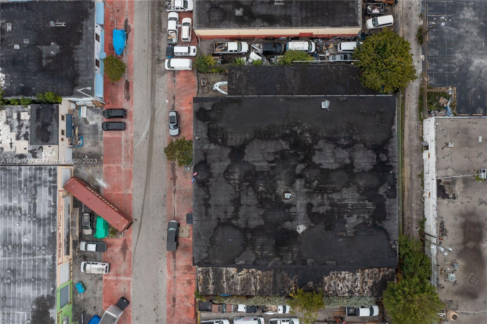 An aerial view shows a flat-roofed industrial building surrounded by parking lots and parked vehicles — 1040 E 26th Street, Hialeah FL 33013, HIALEAH, FL
