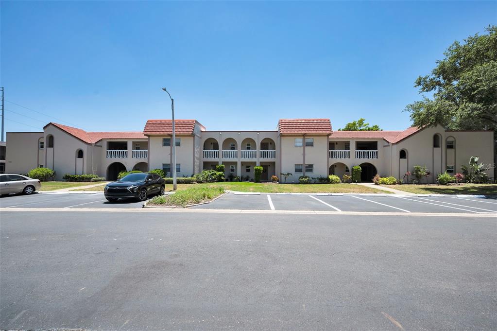 A two-story apartment building with a tiled roof and a parking lot in front — 9700 STARKEY ROAD UNIT 228, SEMINOLE, FL