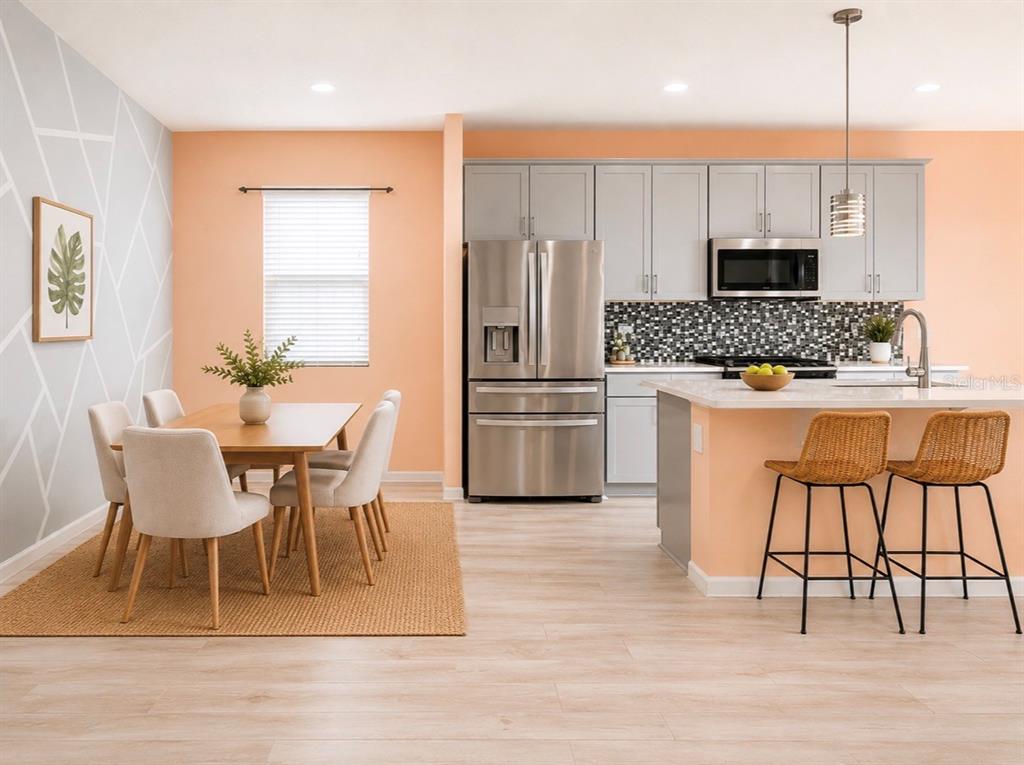 A kitchen and dining area featuring peach walls, gray cabinets, and a light wood floor — 2410 BITTLE WAY, ST CLOUD, FL