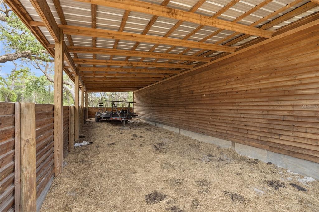 A covered outdoor structure with wooden walls, a metal roof, and a dirt floor — 14405 AMY LANE, HUDSON, FL