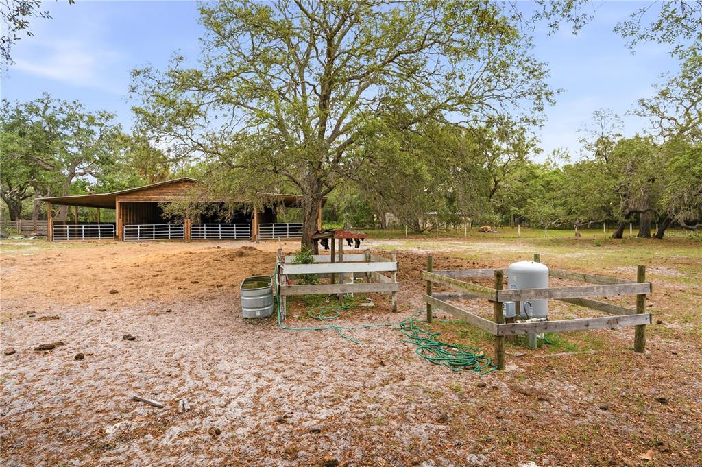 A rural property features a wooden barn, a water tank, and fenced enclosures outdoors — 14405 AMY LANE, HUDSON, FL