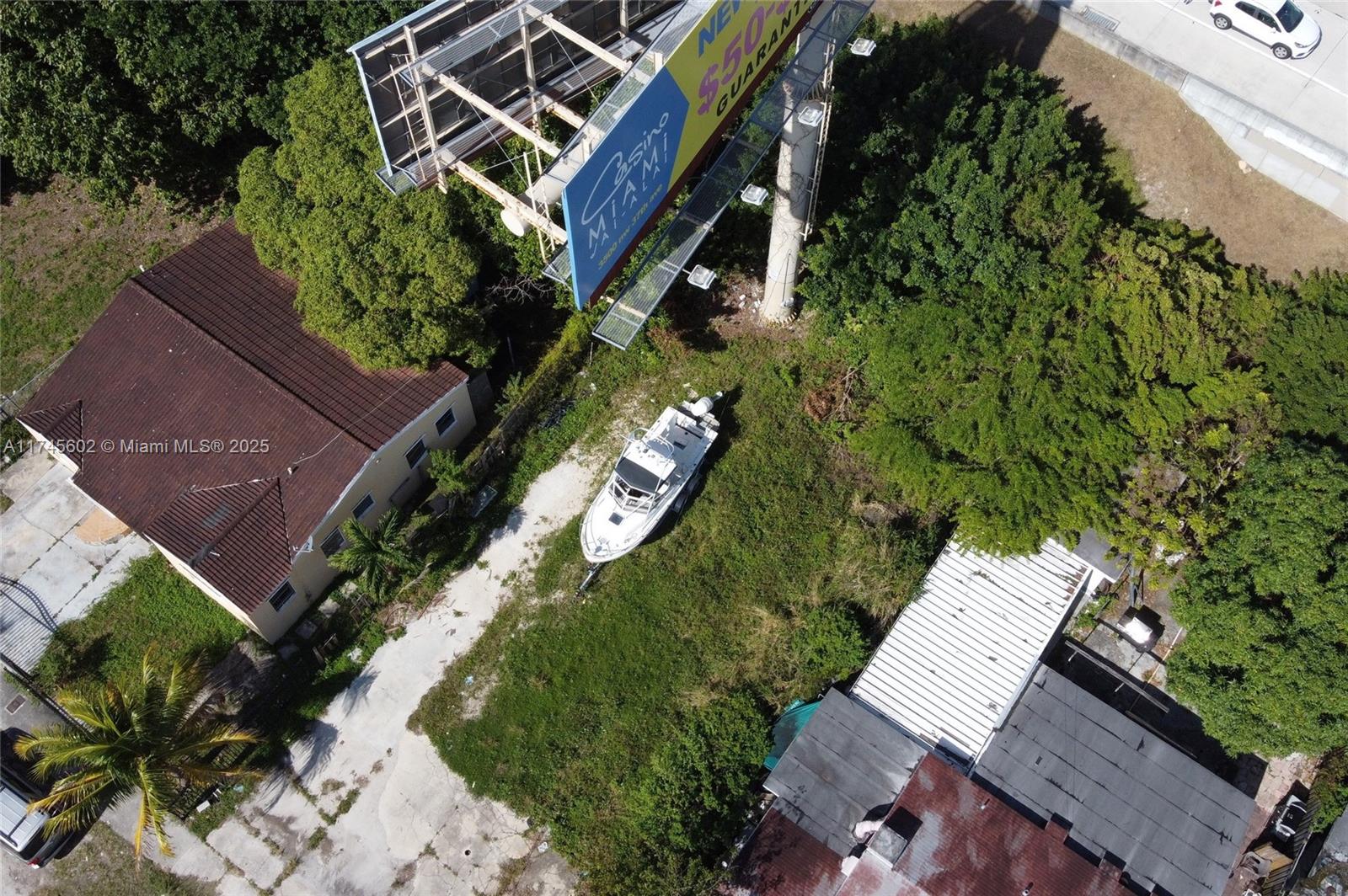 An aerial view shows a boat parked on a grassy lot next to a billboard — 321 NW 37th St, Miami FL 33127, MIAMI, FL