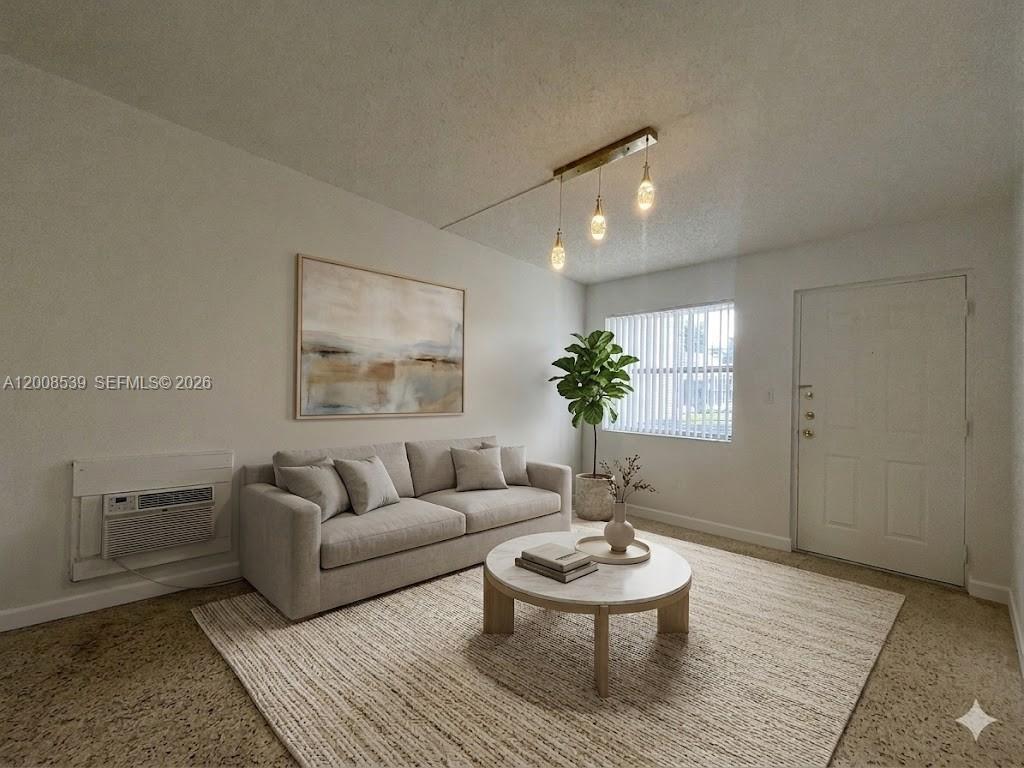 A living room features a beige sofa, round coffee table, area rug, and wall-mounted air conditioner — 142 SW 18th Ave # 20, Miami FL 33135, MIAMI, FL
