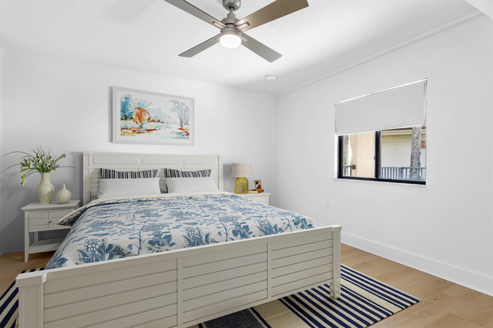 A bedroom features a white bed frame, blue and white bedding, and a ceiling fan — 601 Seafarer Circle # 101, Jupiter FL 33477, JUPITER, FL