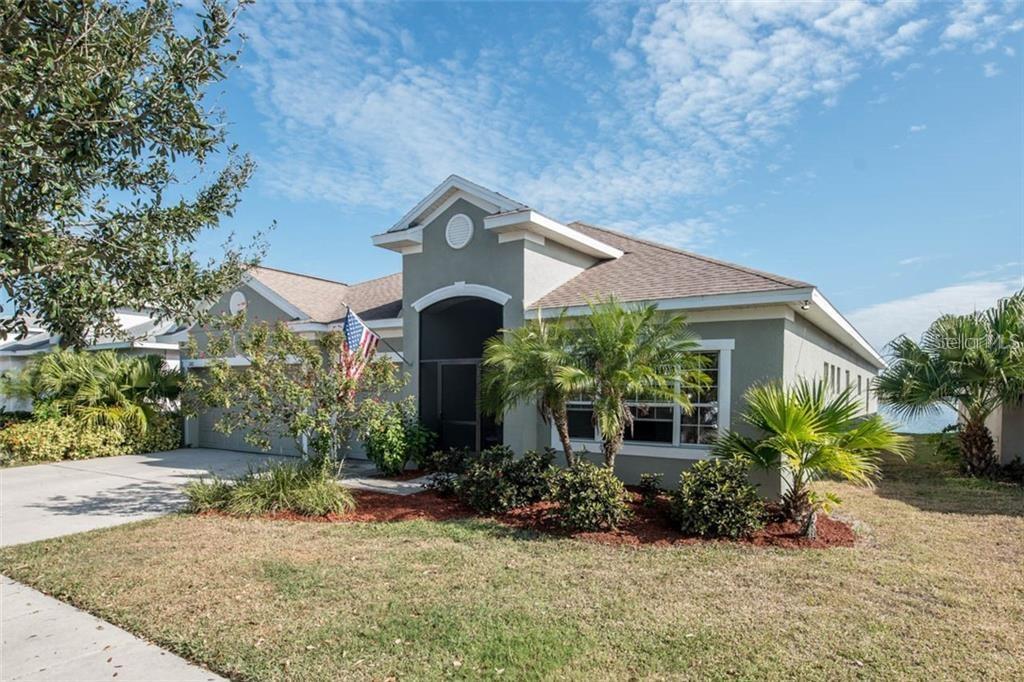 A single-story house with a gray exterior, a two-car garage, and a front entryway — 1742 MIRA LAGO CIRCLE, RUSKIN, FL