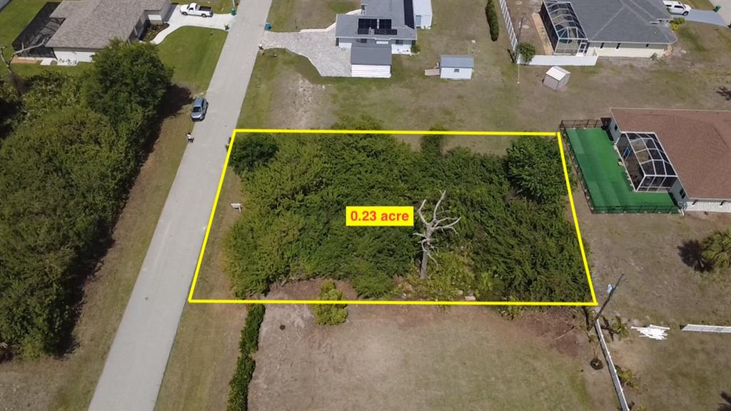 An aerial view shows a rectangular, tree-covered vacant lot outlined in yellow — 7250 PEACOCK LANE, ENGLEWOOD, FL