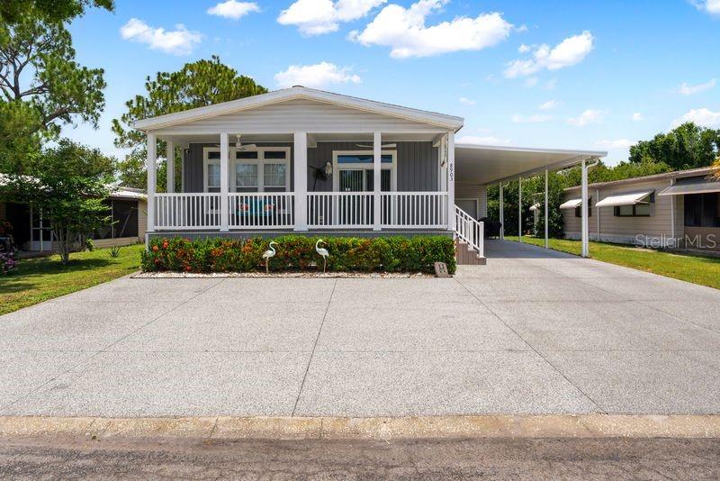 A single-story manufactured home features a front porch, a carport, and a concrete driveway — 8903 SHELDON WEST DRIVE, TAMPA, FL