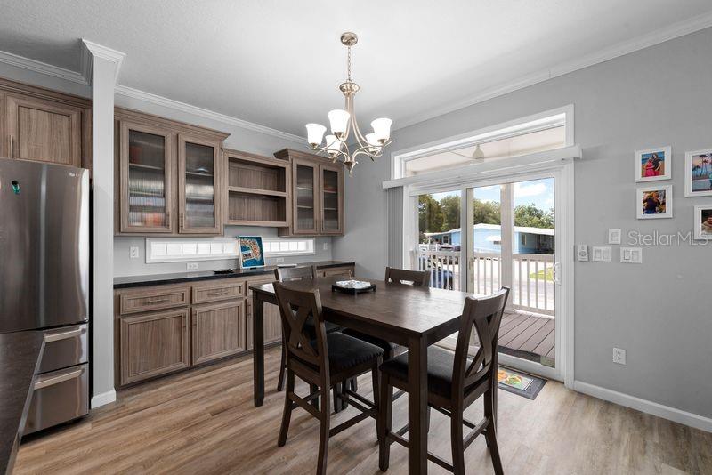 A dining area features a wooden table, chairs, cabinetry, and a sliding glass door — 8903 SHELDON WEST DRIVE, TAMPA, FL