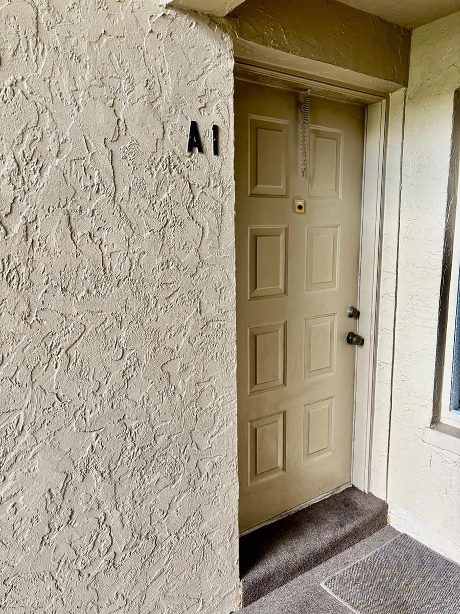 A tan exterior door labeled A1 with a textured wall and a small step — 503 Shady Pine Way # A1, FL 33415, FL