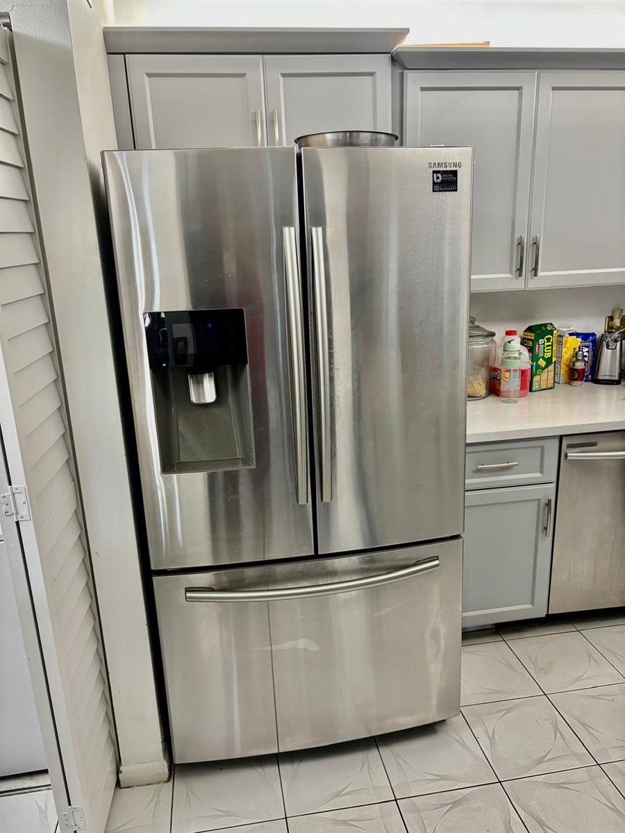 A stainless steel Samsung French door refrigerator stands in a kitchen with grey cabinets — 503 Shady Pine Way # A1, FL 33415, FL