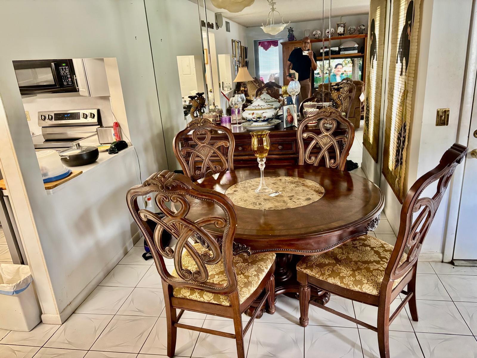 A dining area features a round wooden table with four ornate chairs and mirrored walls — 503 Shady Pine Way # A1, FL 33415, FL