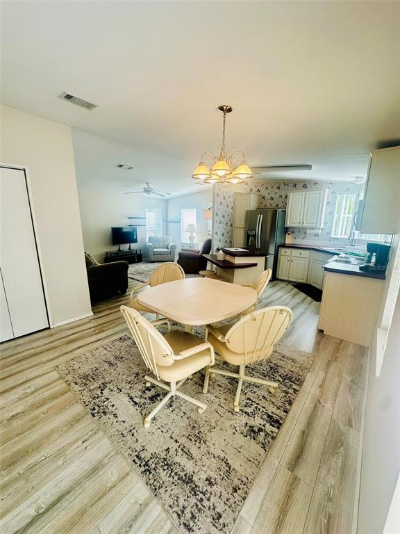 An open-concept dining area with a round table and chairs sits adjacent to the kitchen — 2305 BAY DRIVE, BRADENTON, FL