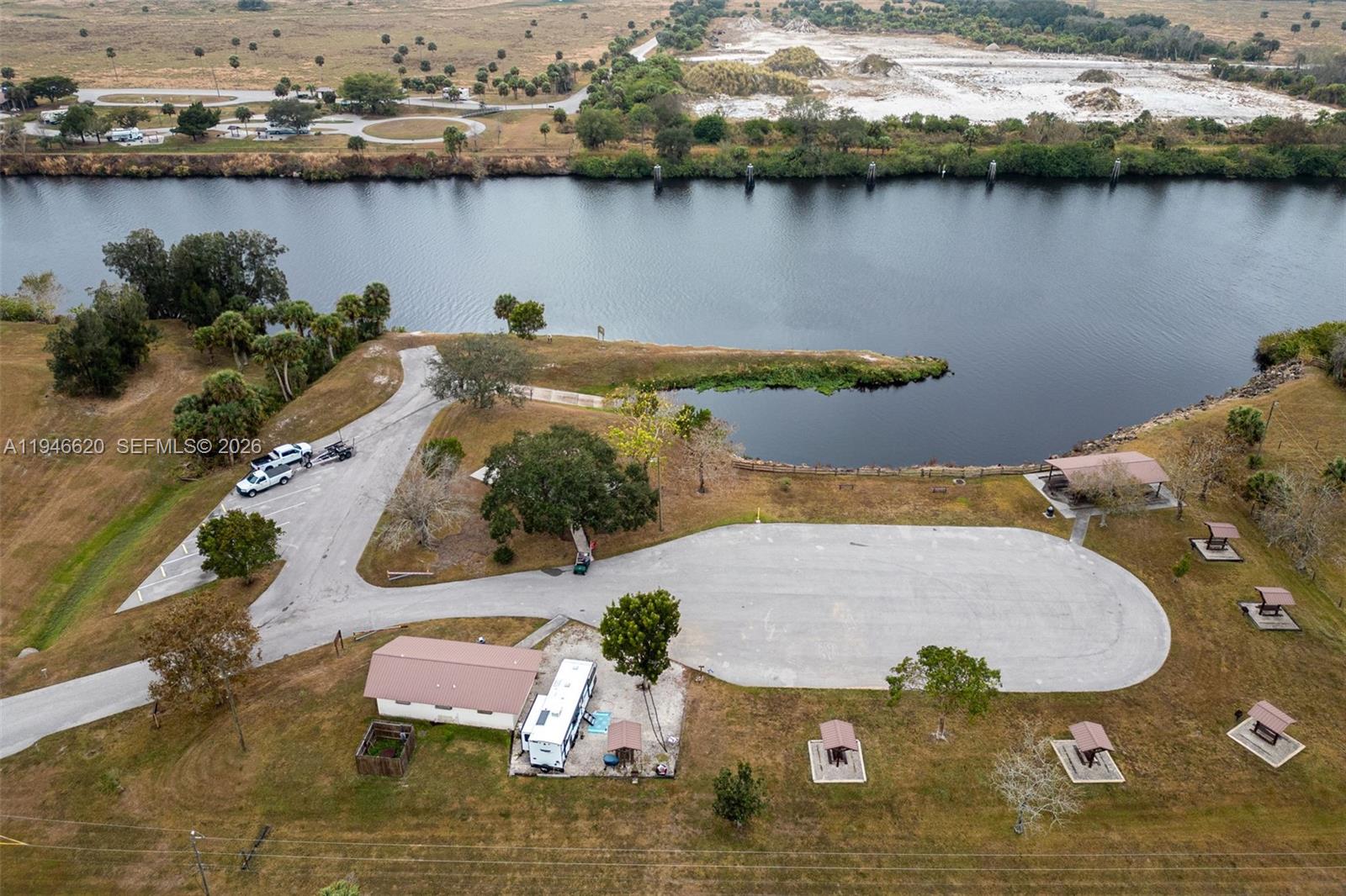 A single-story house with light gray siding and a shingled roof sits on a lawn — 2915 Ortona Locks Rd, Moore Haven FL 33471, MOORE HAVEN, FL