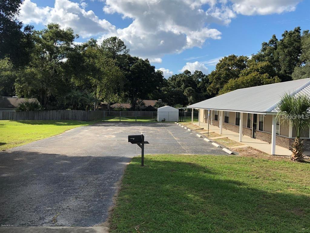 An asphalt parking lot sits in front of a single-story building with a metal roof — 1100 SE 58TH AVENUE UNIT A, OCALA, FL