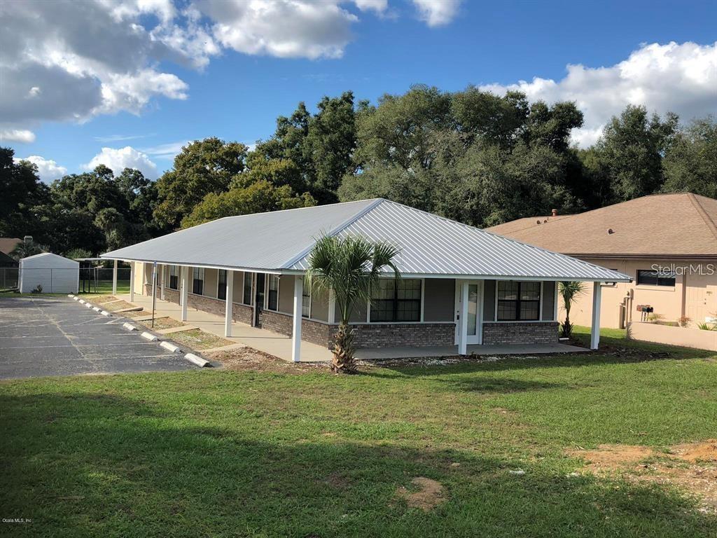 A single-story building with a metal roof, brick facade, and a covered front porch — 1100 SE 58TH AVENUE UNIT A, OCALA, FL