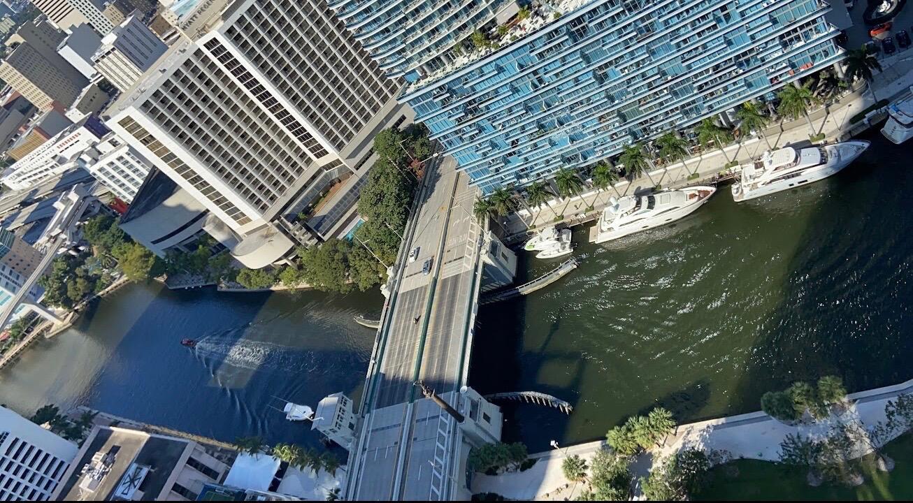An aerial view shows a drawbridge over a river flanked by high-rise buildings and yachts — 475 Brickell Avenue # 4615, Miami FL 33131, MIAMI, FL