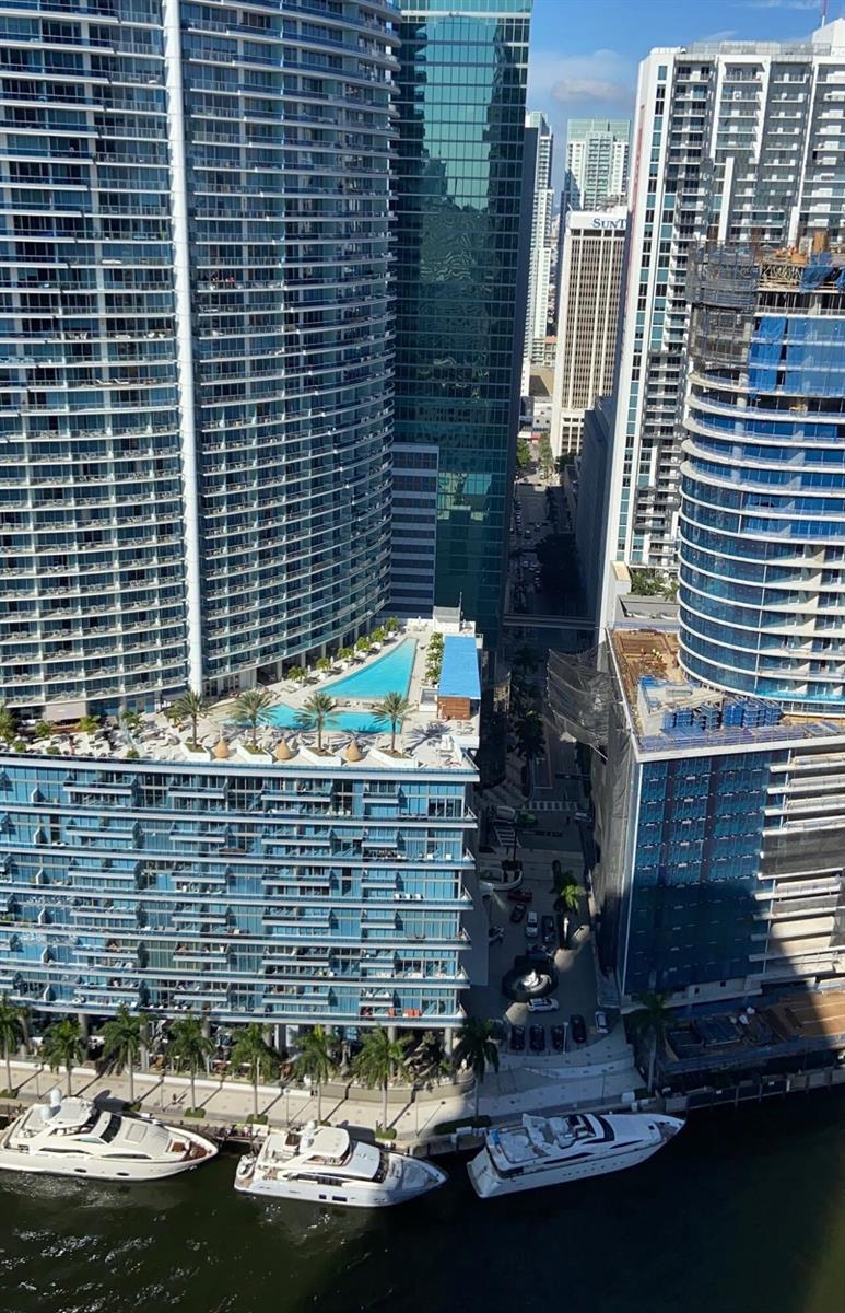 An aerial view of a waterfront high-rise building featuring a triangular pool deck and yachts — 475 Brickell Avenue # 4615, Miami FL 33131, MIAMI, FL