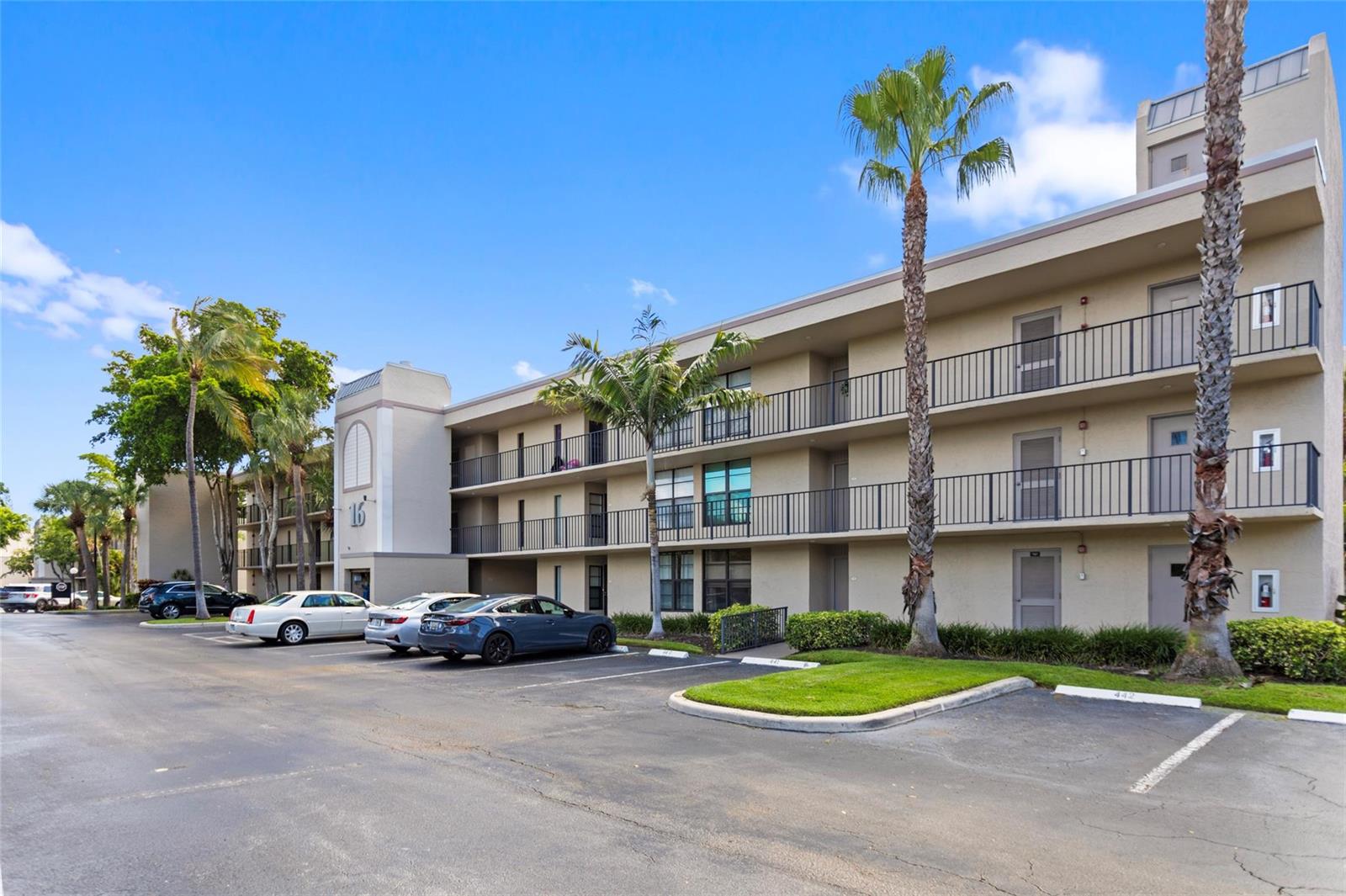 A three-story apartment building with balconies and a parking lot in front — 16 Royal Palm Way # 302, Boca Raton FL 33432, BOCA RATON, FL