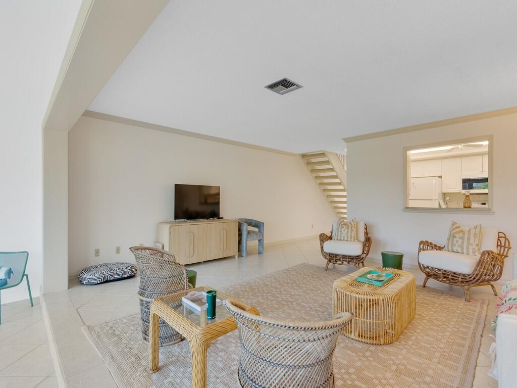 A living room with tile floors, wicker furniture, and a view into the kitchen — VERO BEACH, FL