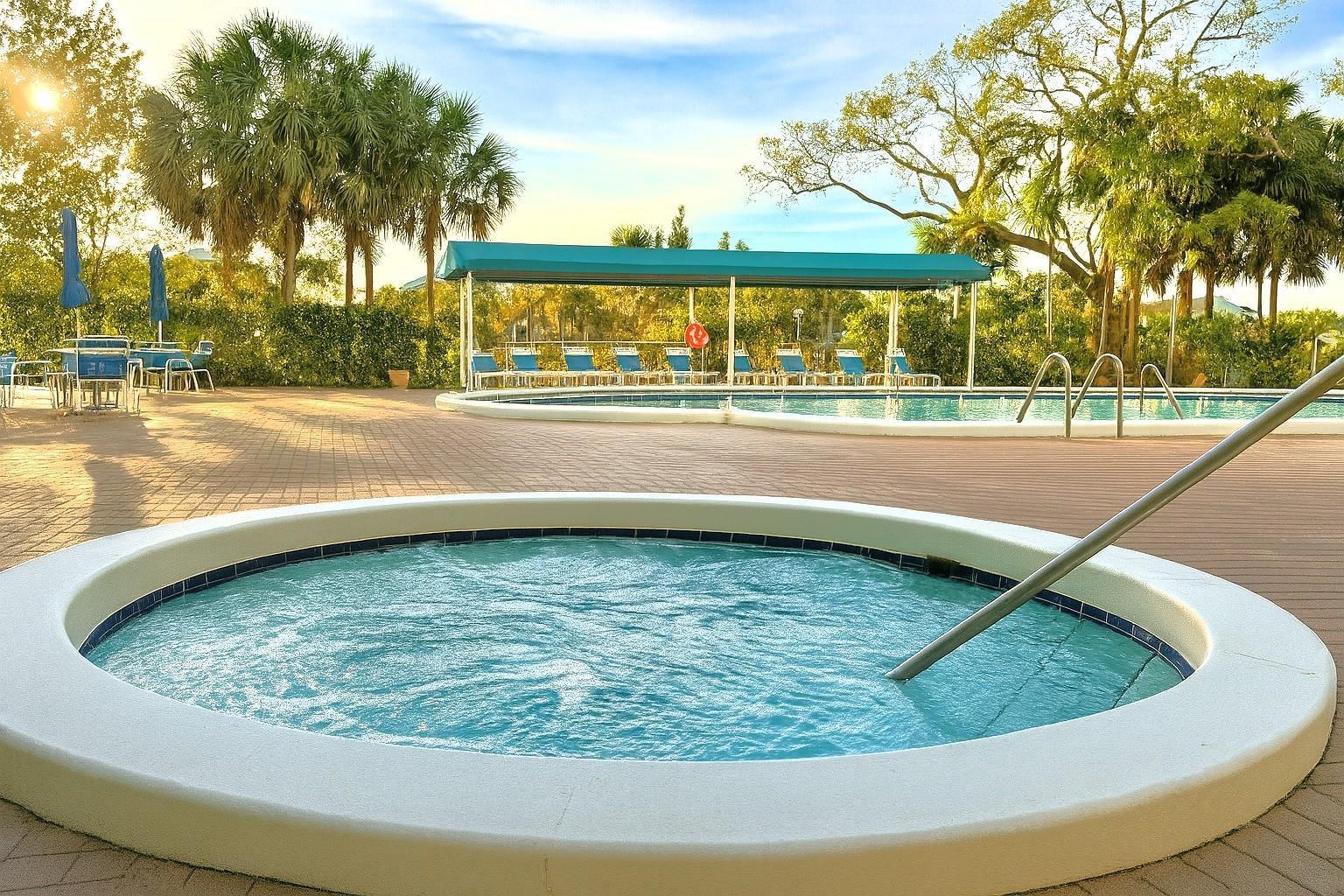 A round hot tub sits on a paved pool deck near a larger swimming pool — 4001 Hillcrest Drive # 407, Hollywood FL 33021, HOLLYWOOD, FL