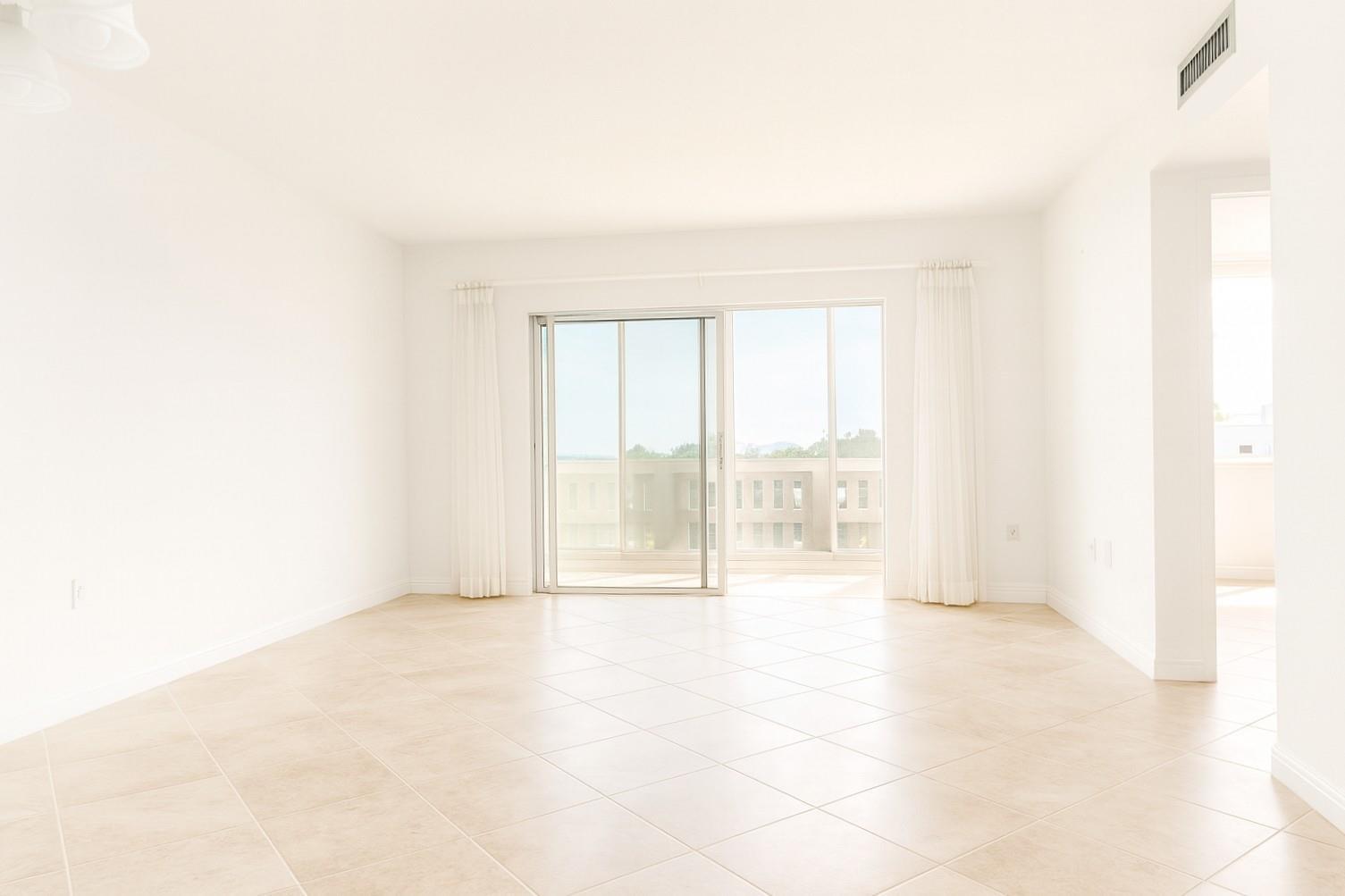 An empty room with white walls, beige tile flooring, and a sliding glass door — 4001 Hillcrest Drive # 407, Hollywood FL 33021, HOLLYWOOD, FL
