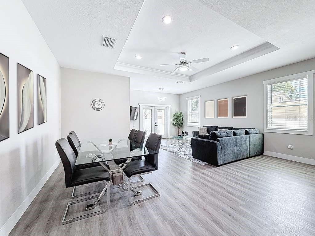 A dining area with a glass table and chairs opens into a living room — 1409 W WOOD STREET, TAMPA, FL