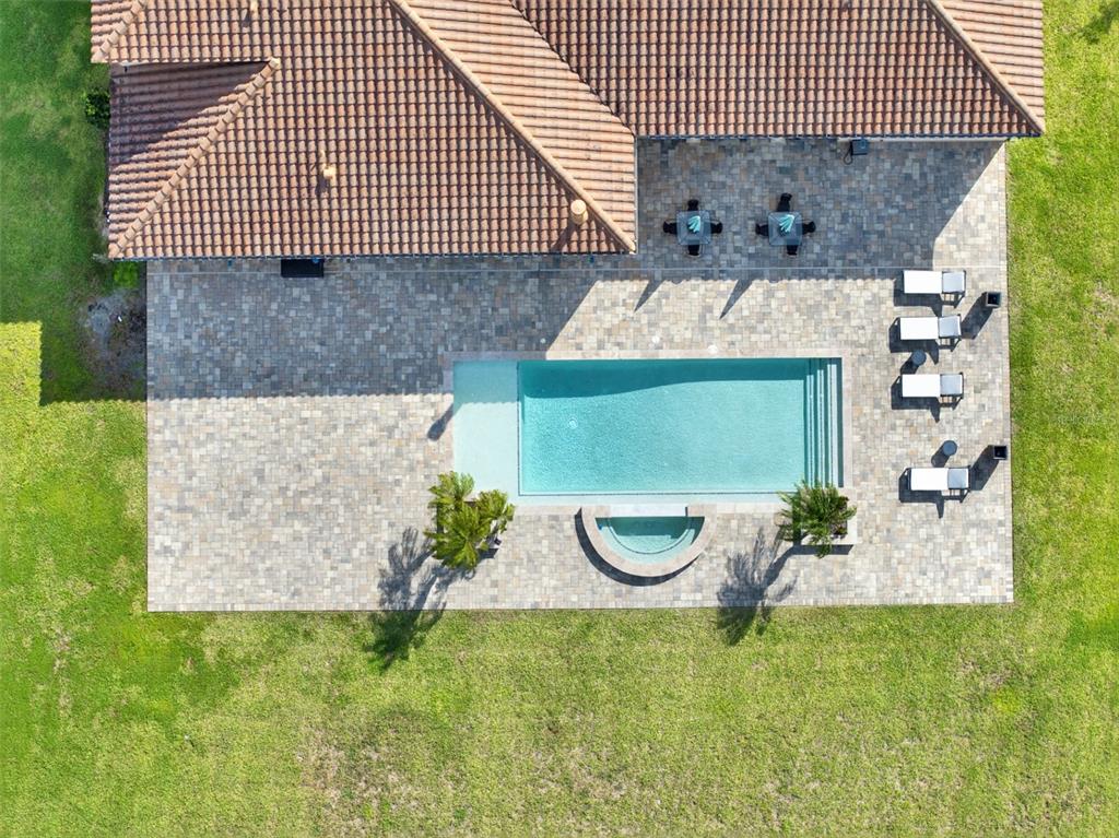 An aerial view shows a house with a tiled roof, a pool, and a paved patio — 3764 FARM BELL PLACE, LAKE MARY, FL