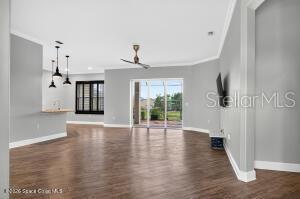 An open-concept living area features wood-look flooring, gray walls, a ceiling fan, and sliding glass doors — 1475 DALBORA ROAD, MERRITT ISLAND, FL