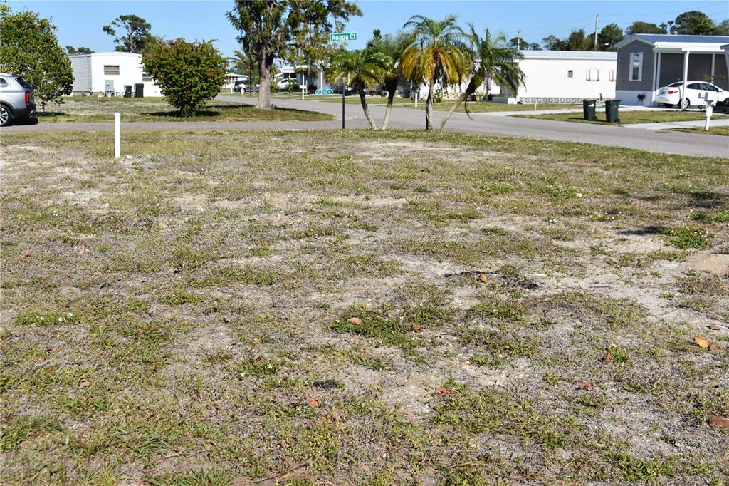 A vacant, grassy residential lot is situated on a corner in a mobile home community — 6805 ANAPA COURT, NORTH PORT, FL