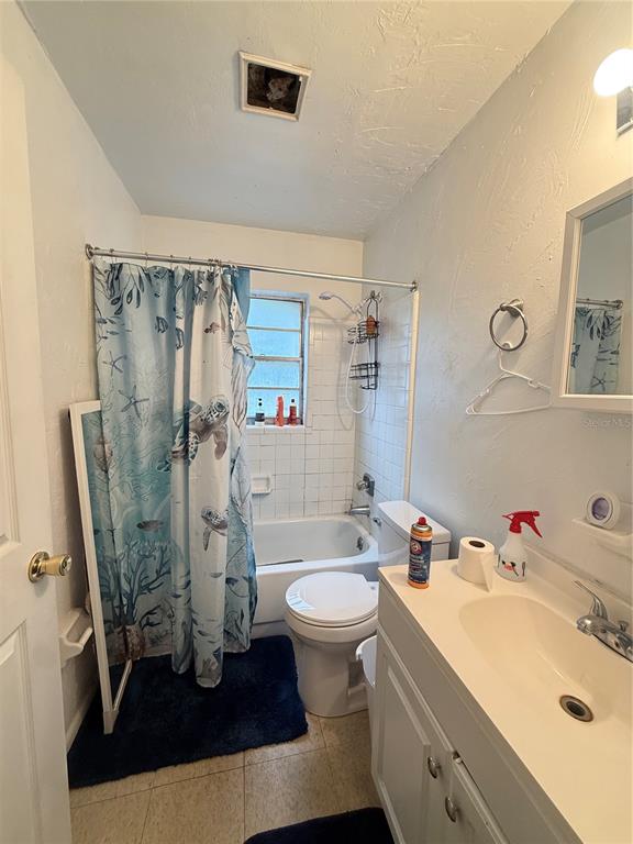 A small bathroom features a tub-shower combo with a sea-themed curtain and a white vanity — 615 SW 11TH LANE UNIT A, GAINESVILLE, FL