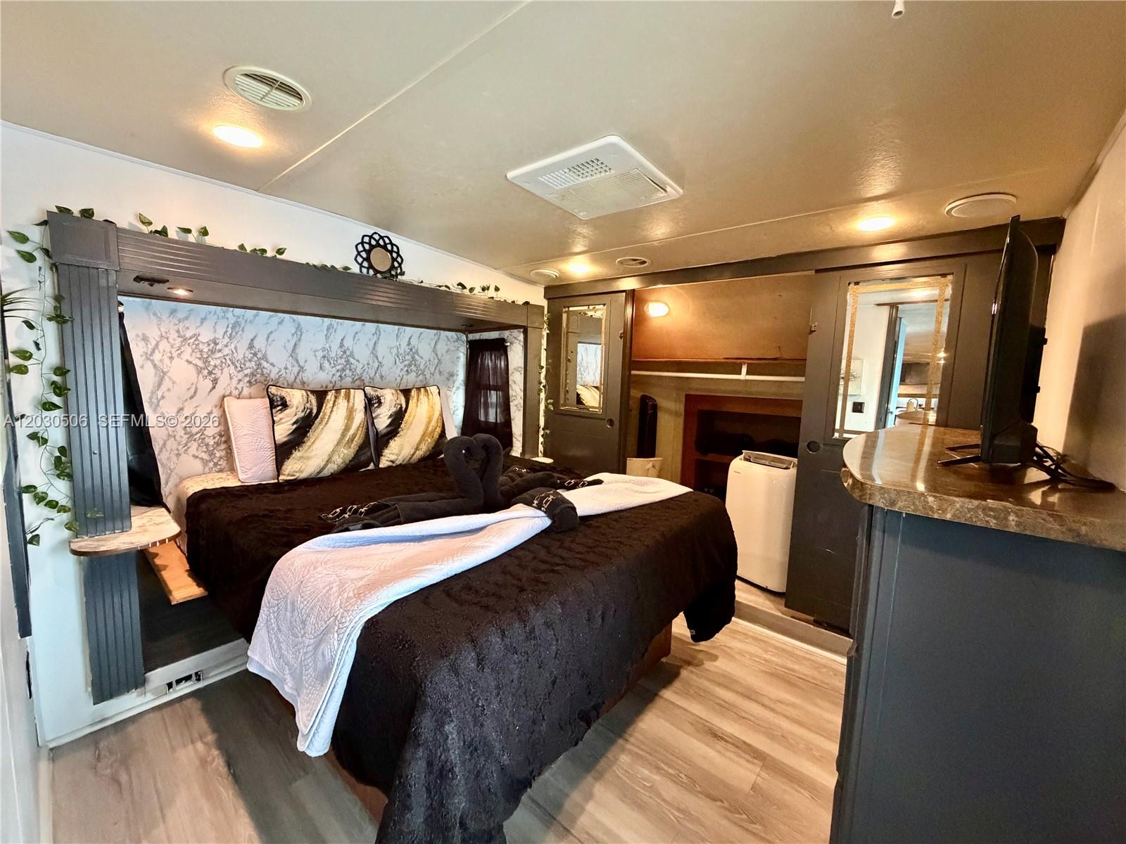 A bedroom features a bed with a marble-patterned headboard, dark wood accents, and light flooring — 325 Calusa Street #409, Key Largo FL 33037, KEY LARGO, FL